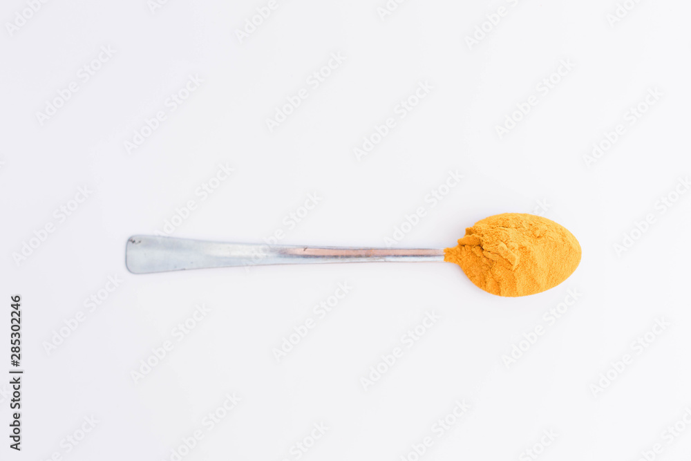 Turmeric powder in the spoon isolated on white background Turmeric powder in the spoon isolated on white background