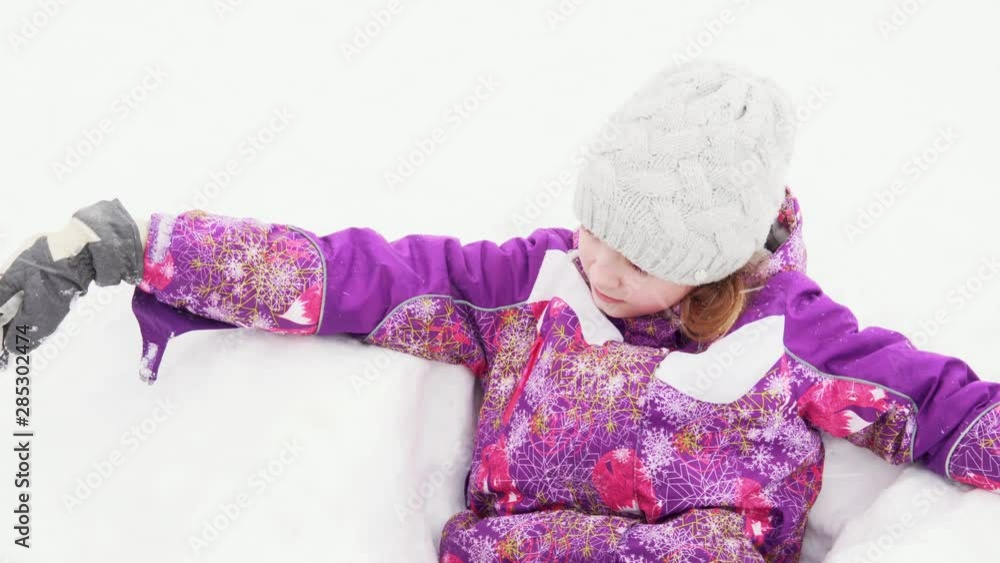 Teen girl playing outdoors in winter. The child has fun in the snow in the village. Teen girl playing outdoors in winter. The child has fun in the snow in the village.