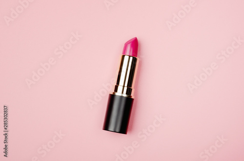 Obraz na płótnie Pink lipstick tube, lip gloss top view. Beauty industry concept. Glamorous makeup accessory close up on pastel pink background. Women fashion product, style. Cosmetology, female elegance attribute w salonie
