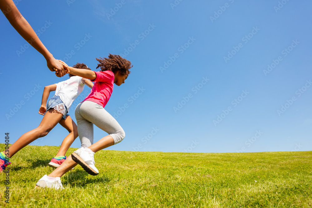 Side view of girls run on the grass park field Side view of girls run on the grass park field