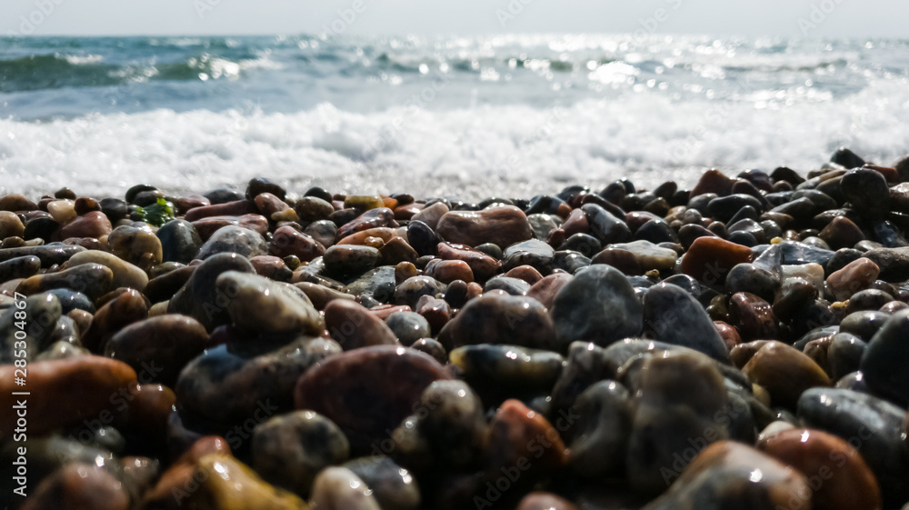 Pebble beach and oncoming wave as background. Calm concept Pebble beach and oncoming wave as background. Calm concept