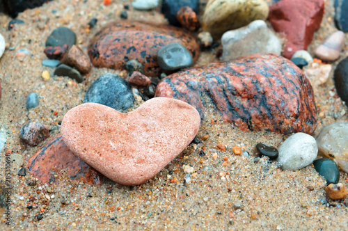 Sea stone heart shape. Sea stone texture. Panel texture. Spots gray red background. Background fill. Natural stone background.