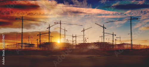 Gruas de construcción y puesta de sol.Concepto de industria y mercado inmobiliario..Cimientos de bloque de pisos