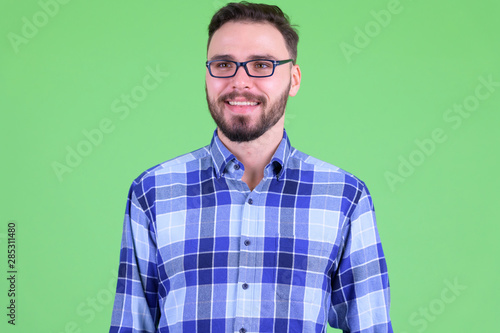 Face of happy young bearded hipster man thinking © Ranta Images