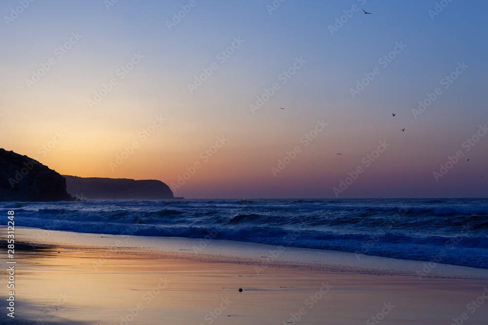 Obraz premium Sunset on beautiful beach at Salema, Portugal