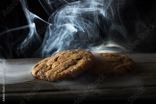 oatmeal cookies in smoke on wooden table photo