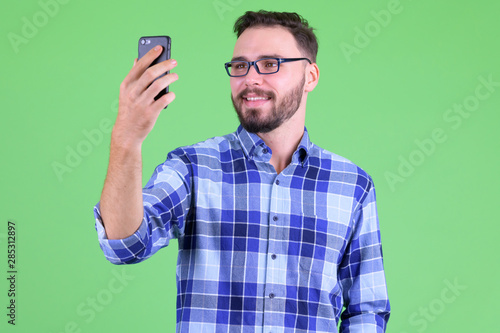 Happy young bearded hipster man taking selfie © Ranta Images