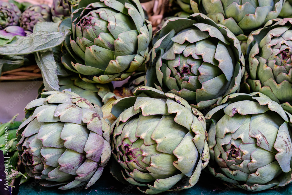 Obraz premium Fresh ripe organic globe artichokes displayed for sale at a street food market