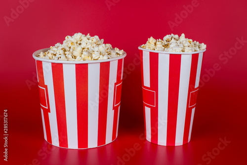 Full size length photo of two middle and bid size containers full of tasty yummy fresh popcorn with place for label text isolated vivid background