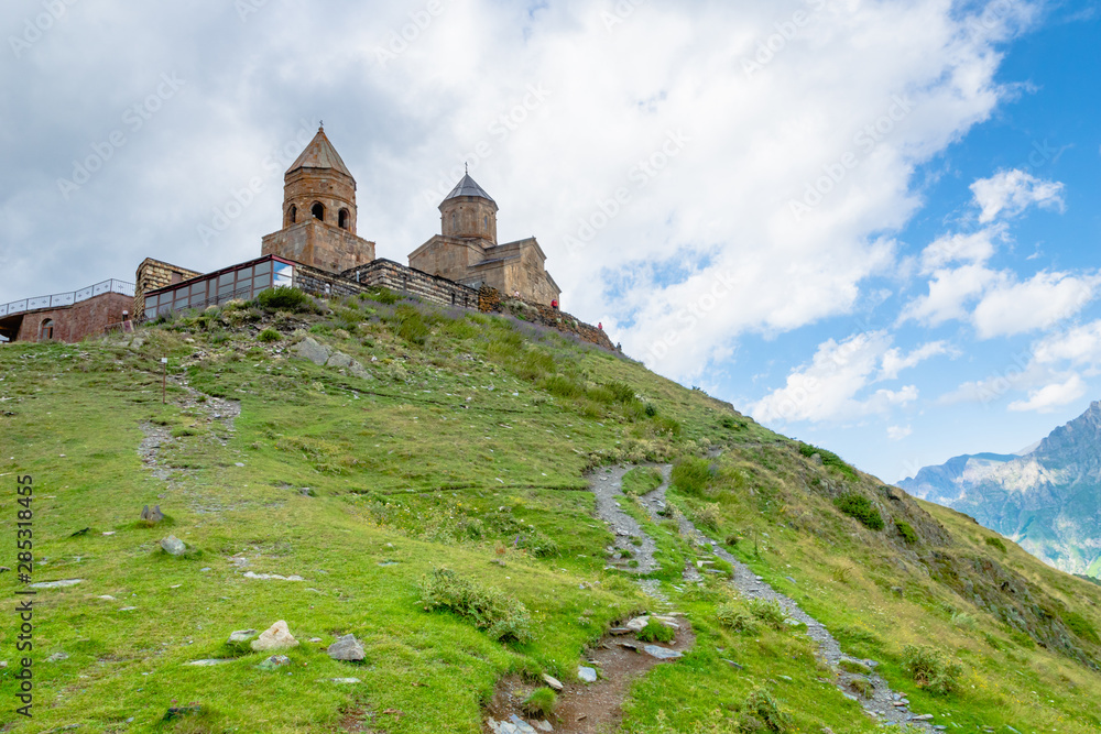 Gergeti Trinity Church or Tsminda Sameba, dramatic landscaoe with clouds. Gergeti Church stands near the village of Gergeti in Georgia, under Mount Kazbegi, Georgia Gergeti Trinity Church or Tsminda Sameba, dramatic landscaoe with clouds. Gergeti Church stands near the village of Gergeti in Georgia, under Mount Kazbegi, Georgia