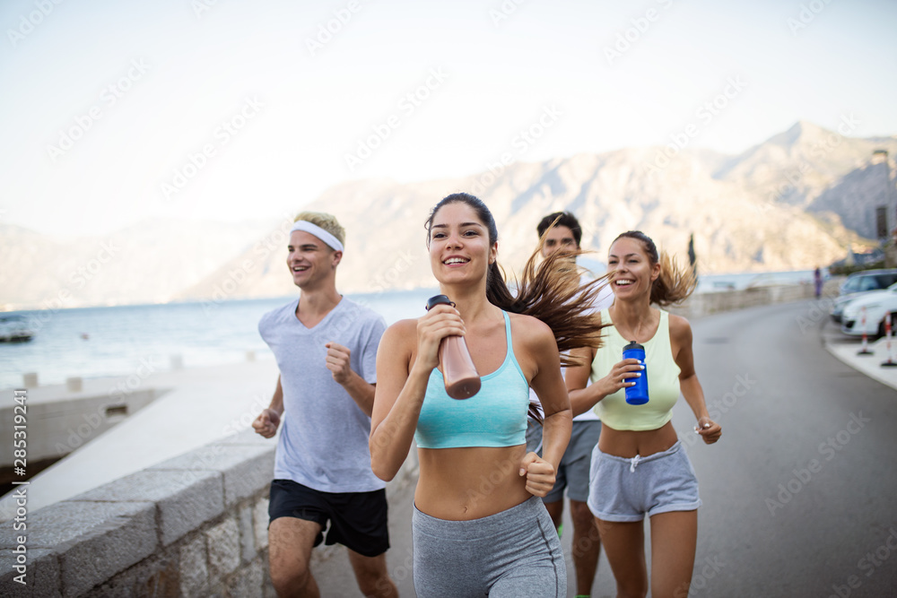 Happy people jogging outdoor. Running, sport, exercising and healthy lifestyle concept - obrazy, fototapety, plakaty 