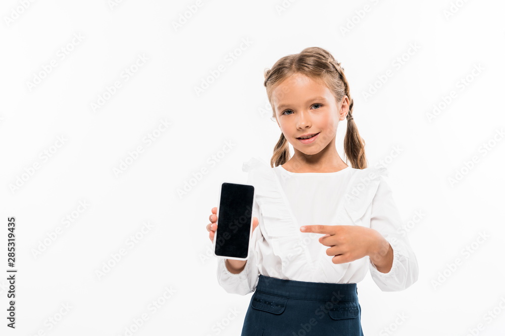 happy kid pointing with finger at smartphone with blank screen isolated on white happy kid pointing with finger at smartphone with blank screen isolated on white
