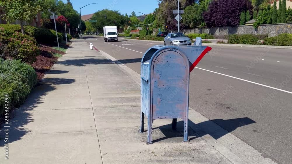 Old Blue Mailbox on Sidewalk Next To a Street Old Blue Mailbox on Sidewalk Next To a Street