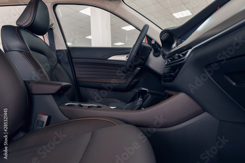 Leather car interior. Modern car illuminated dashboard. Luxurious car instrument cluster. Close up shot of automobile instrument panel. Modern car interior dashboard and steering wheel © svetlichniy_igor