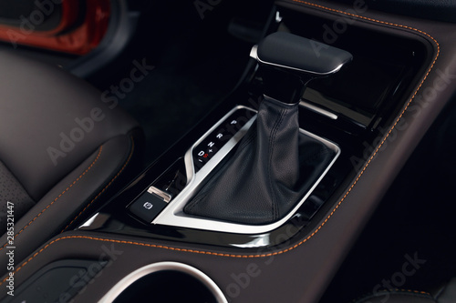 Selector automatic transmission with perforated leather in the interior of a modern expensive car. The background is blurred © svetlichniy_igor