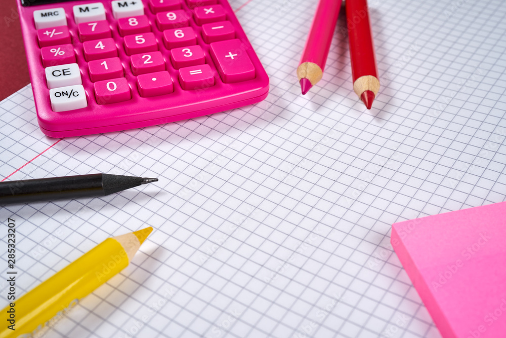 open notebook with checkered pages and calculator and pencil open notebook with checkered pages and calculator and pencil