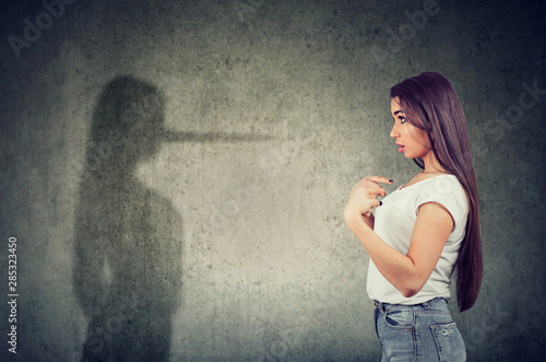 Photo woman pointing at herself looking at a shadow with long nose of a liar