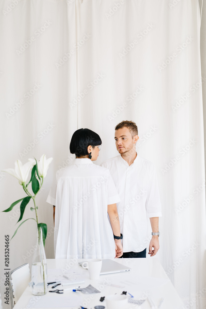 Young modern designers looking at each other in studio Young modern designers looking at each other in studio