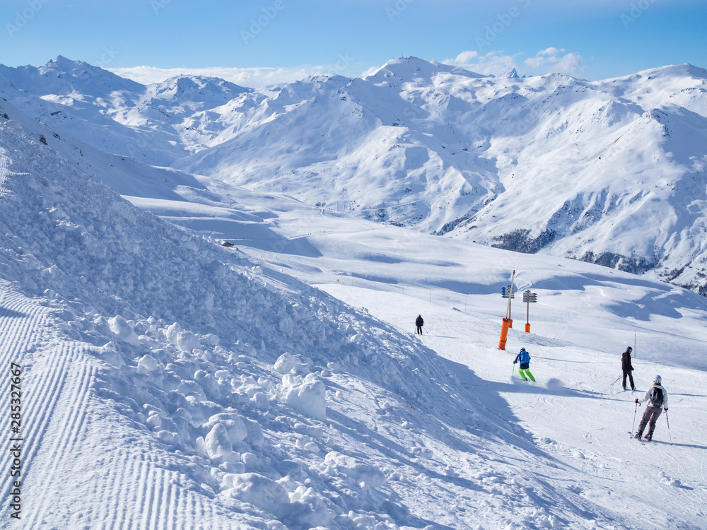 France, Meribel valley: Panoramic landscape view down valley with ski slope piste in winter alpine mountain resort