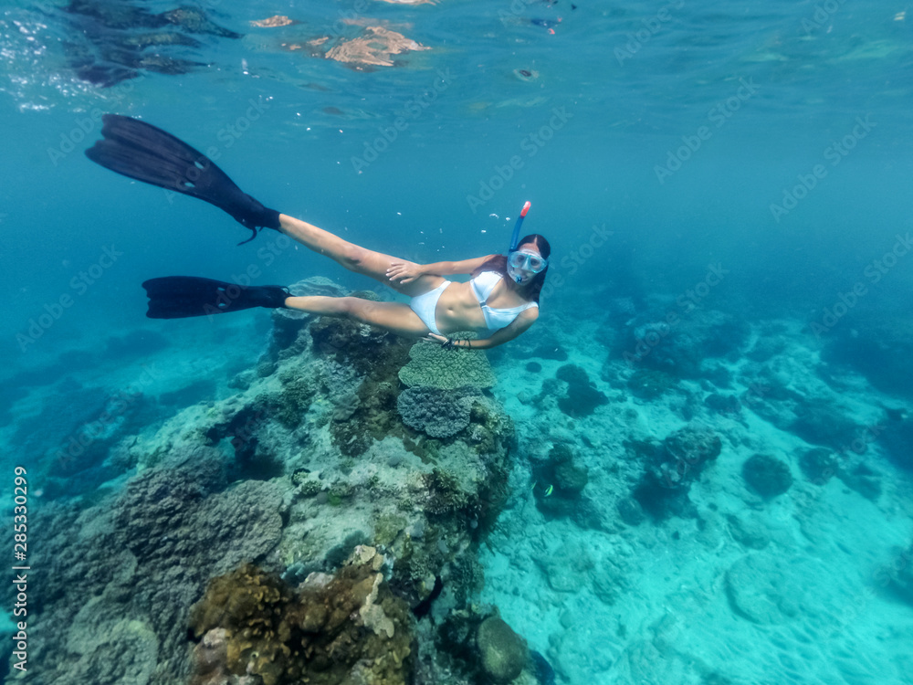 Woman diving In Blue Water With Dive Mask and fins Woman diving In Blue Water With Dive Mask and fins
