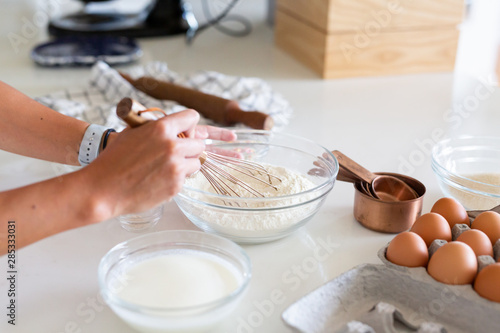 woman whisking flour in kitchen