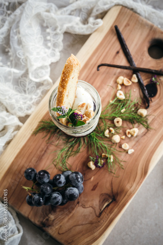 Vanilla Panna Cotta with a Concord Grape Gelee Topped with Whipped Chantilly Cream and Toasted Hazelnut and Served with a Slice of Hazelnut Biscotti