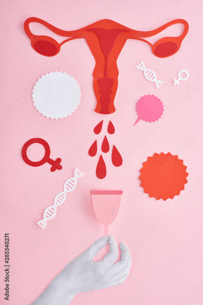 Φωτογραφία cropped view of hand holding menstrual cup near red paper cut female reproductiv