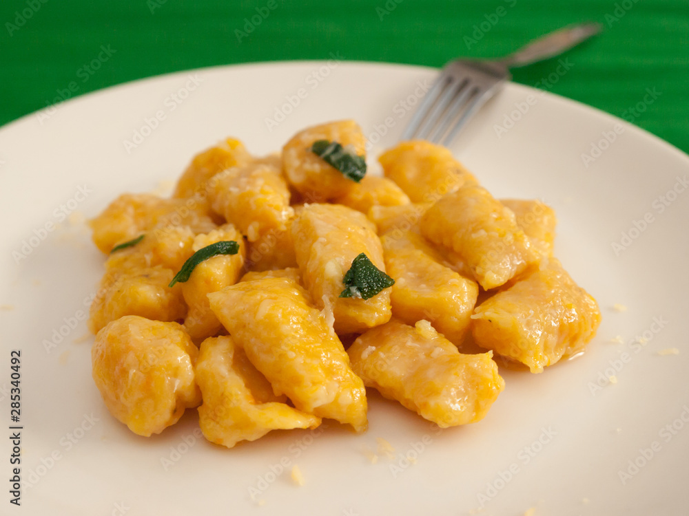 Pumpkin gnocchi with sage and butter on a white plate Pumpkin gnocchi with sage and butter on a white plate