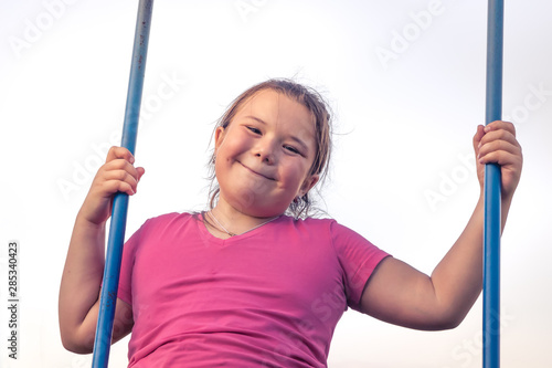 Fotografie Happy plump child girl fun swinging sky happy carefree childhood