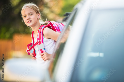Cute little girl going home from school, looking well before crossing the street