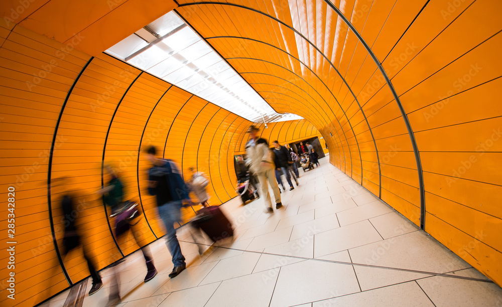 Fototapeta premium People rushing through a subway corridor (motion blur technique is used to convey movement)