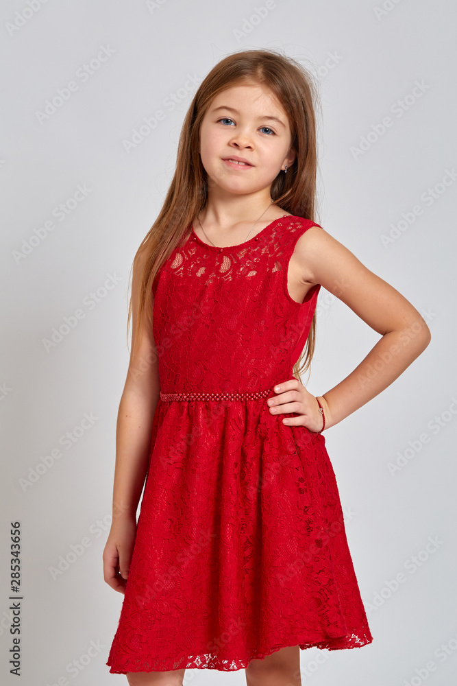 Teenage girl with emotional facial expression. Beautiful female half-length portrait on light background. Teen girl in a beautiful red dress Teenage girl with emotional facial expression. Beautiful female half-length portrait on light background. Teen girl in a beautiful red dress