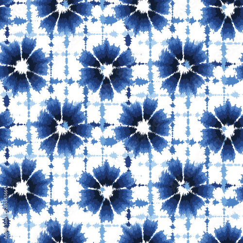 Indigo blue shibori tie dye sunburst flower circle background. Seamless pattern on white background. Japanese style batik floral textile. Variegated for summer fashion swatch.