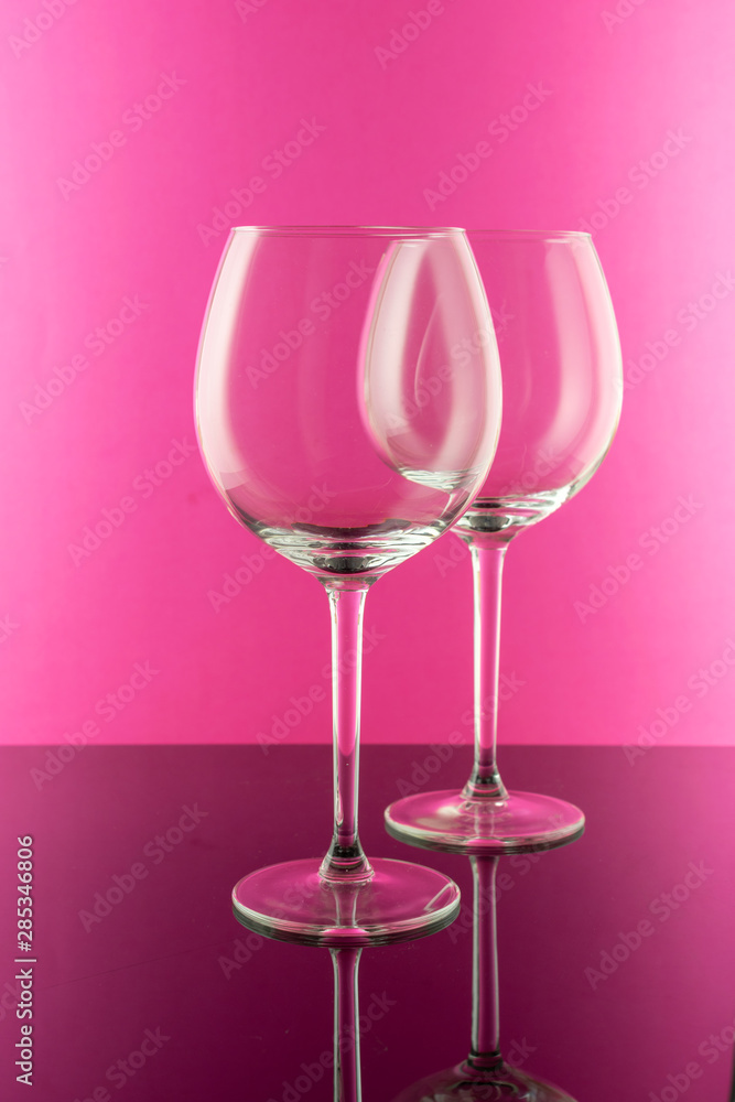 Reflection at the Empty Wine Glasses on pink background. Wine concept. Reflection at the Empty Wine Glasses on pink background. Wine concept.