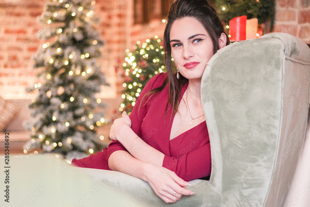 young girl sitting in a chair by the fireplace at christmas young girl sitting in a chair by the fireplace at christmas