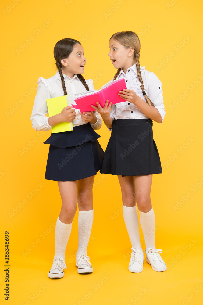 Fototapeta premium Friendship goals. Cute school girls with books. First day at school. Sharing gossips personal diary. School friendship. Most important thing one learns in school is self esteem support and friendship