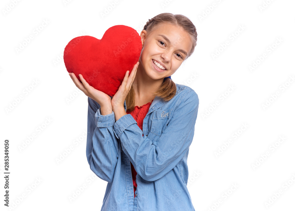 Valentines Day concept. Portrait of cute teen girl with red heart, isolated on white background. Smiling child holds symbol of love, family, hope. Cute caucasian teenager holding plush heart in hands. Valentines Day concept. Portrait of cute teen girl with red heart, isolated on white background. Smiling child holds symbol of love, family, hope. Cute caucasian teenager holding plush heart in hands.