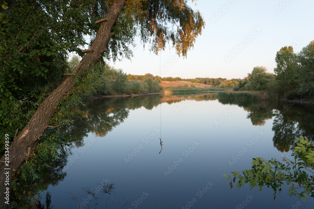 Summer pond at sunset with bungee above the water