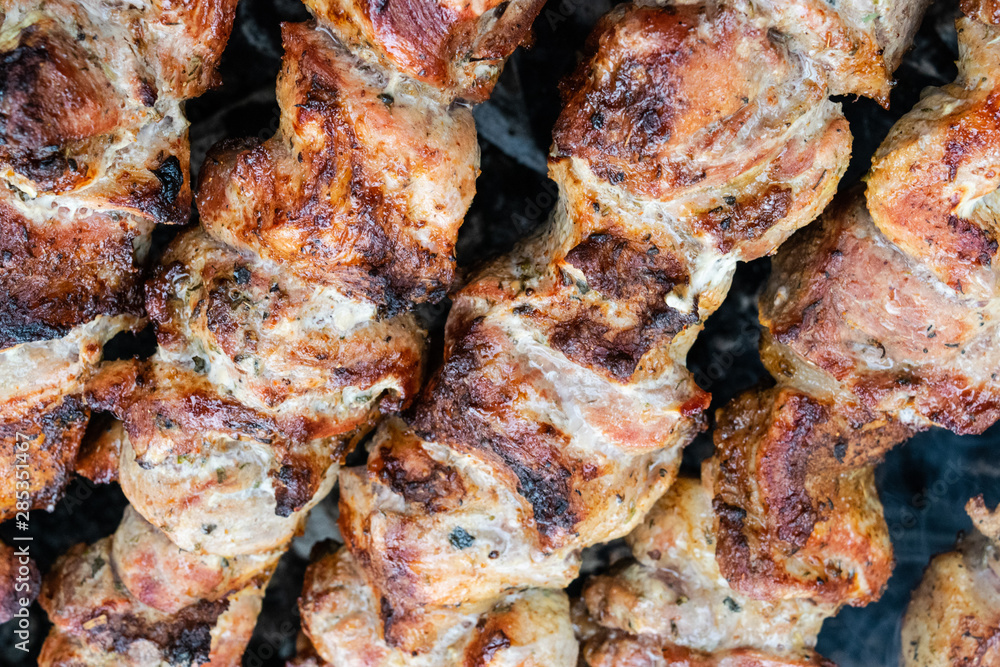 Frying pork on a skewer over a brazier. Turning meat over coals. Appetizing shish kebab. Frying pork on a skewer over a brazier. Turning meat over coals. Appetizing shish kebab.