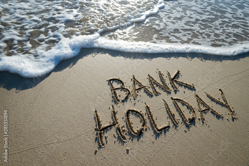 Cuadro en lienzo Bank Holiday message handwritten on the smooth sand of an empty beach with oncom