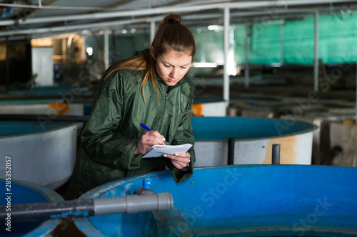 Woman at trout breeding incubator photo