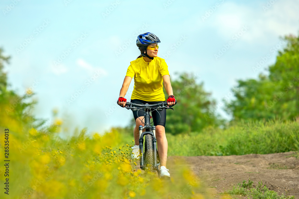 Beautiful girl in yellow riding a bike in nature. Beautiful girl in yellow riding a bike in nature.