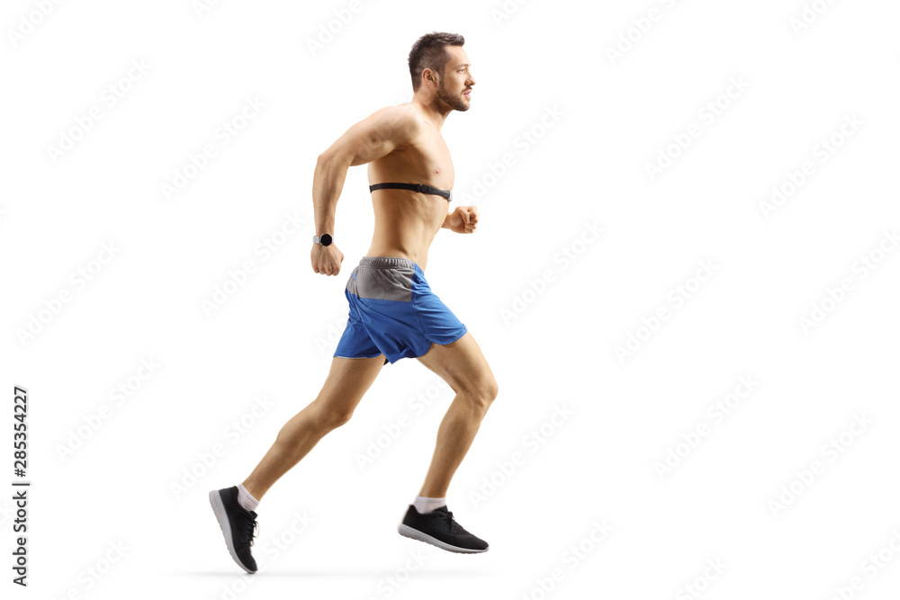 Young man running and wearing a chest strap monitor