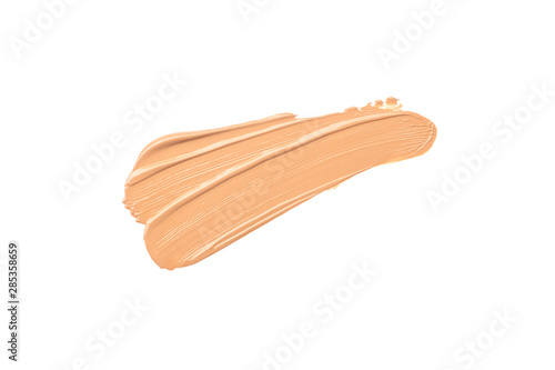 Bright beige smear of foundation in the form of a group of diagonal strokes isolated on a white background.