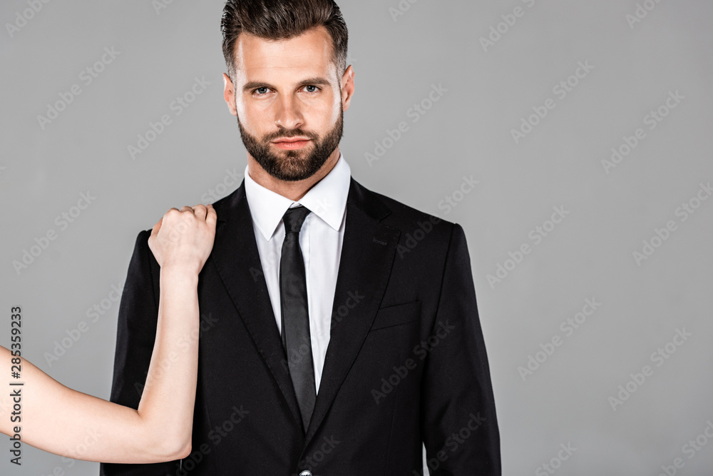 woman touching successful businessman in black suit isolated on grey woman touching successful businessman in black suit isolated on grey