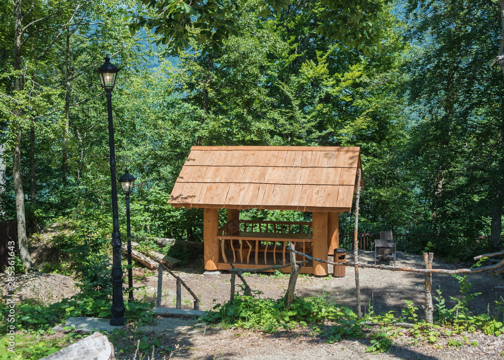 Beautiful summer house from a log of a large tree with barbecue for barbecue in forest Beautiful summer house from a log of a large tree with barbecue for barbecue in forest