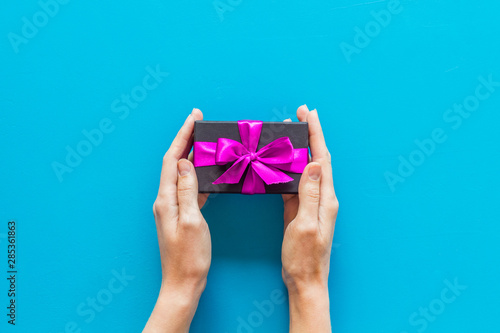 box for gifts in hands on blue background top view mock up