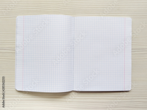 Foto White school notebook in a cage is on a wooden table