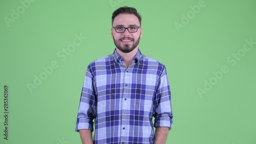Happy young bearded hipster man talking to camera