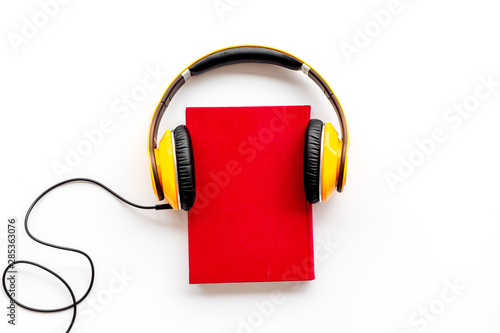 listen to audio books with headphone on white background flatlay